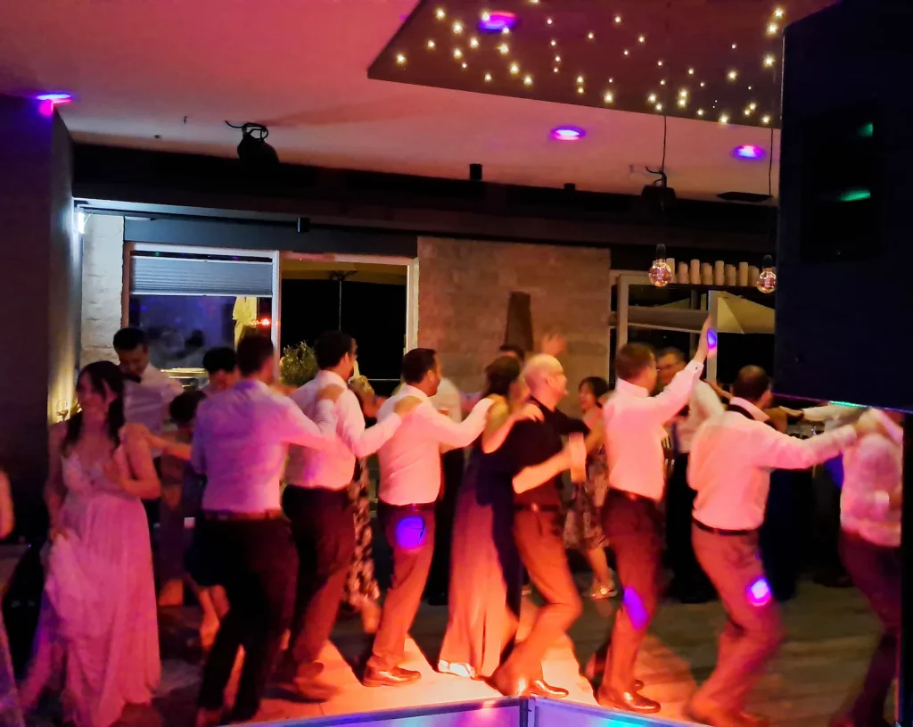Hochzeitsgäste tanzen eine Polonaise unter einer Decke mit sternförmigen Lichtern